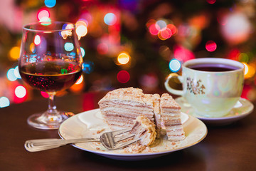 Christmas dessert. Cake on plate and brandy in glass
