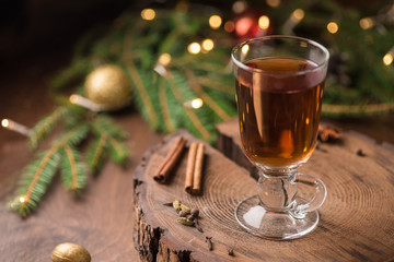 Spiced Apple Cider Mulled Sangria in glass cup on wooden background. Hot drinks for Christmas.