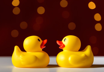 Rubber duck toys on a shiny light dark red background
