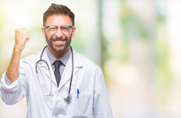 Adult hispanic doctor man over isolated background angry and mad raising fist frustrated and furious while shouting with anger. Rage and aggressive concept.