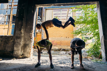 Parkour guy jump over friends in abandoned factory