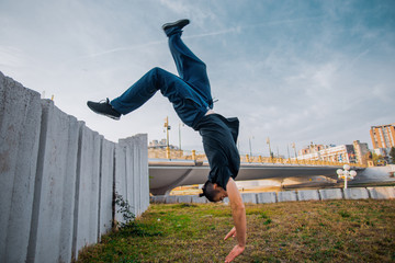 Parkour man doing handstand in urban place