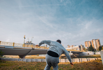 Young sporty man practicing parkour on the ground