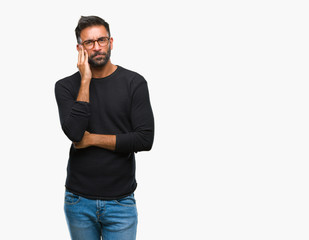 Adult hispanic man wearing glasses over isolated background thinking looking tired and bored with depression problems with crossed arms.