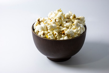 Popcorn in wooden bowl isolated on white background. Selective focus.