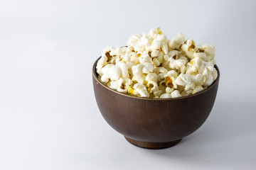Popcorn in wooden bowl isolated on white background. Selective focus.