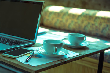 two cups of hot coffee on table with notebook and smartphone,project team teamwork concept