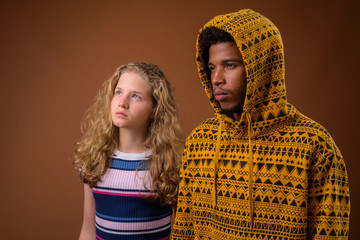 Portrait of young African man and Caucasian teenage girl thinking