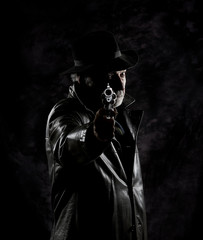 An old private detective armed with a vintage revolver in front of a black textured backdrop.