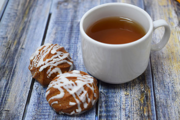 A Cup of fragrant tea and delicious sweet cookies on a wooden background.