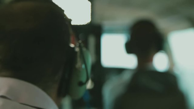 A small airplane flying over the water focus is shifting between the co-pilot and a man sitting in the back of the airplane. No camera movements. Filmed in realtime.