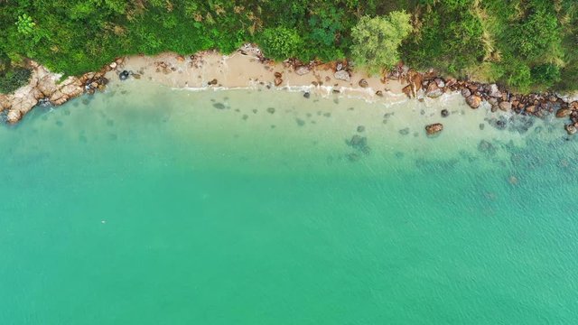 Aerial top view of ocean waves, beach and rocky coastline and beautiful forest. Beautiful nature background. 4k