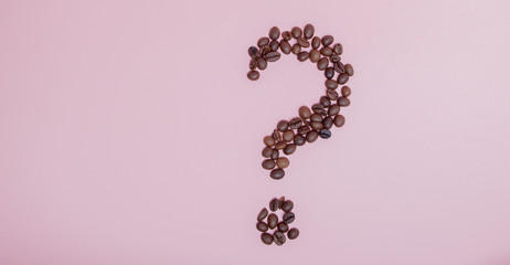 The coffee beans in shape of question mark, isolated on pink background