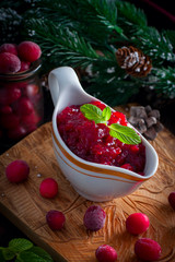 Cranberry sauce in a gravy boat on a wooden board, selective focus