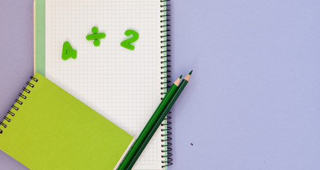 Learning maths. Kid's desk with blank notebook, colorful pencils and numbers top view with copy space