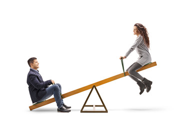 Young man and woman playing on a seesaw