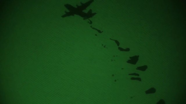 Night vision shot of an aircraft parachuting boxes near the Iraqi-Syrian border