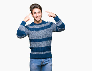 Young handsome man over isolated background Smiling pointing to head with both hands finger, great idea or thought, good memory