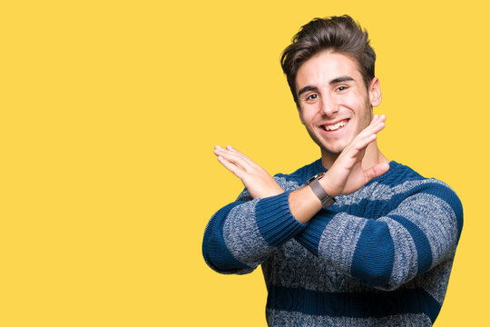 Young handsome man over isolated background Rejection expression crossing arms doing negative sign, angry face