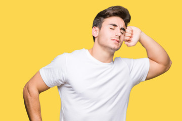 Young handsome man wearing white t-shirt over isolated background stretching back, tired and relaxed, sleepy and yawning for early morning