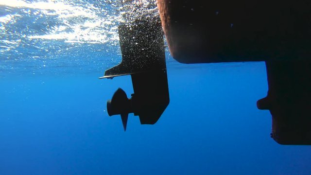 Underwater shot of boat propeller engine spinning.
