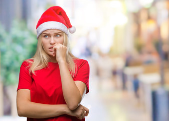 Young caucasian woman wearing christmas hat over isolated background looking stressed and nervous with hands on mouth biting nails. Anxiety problem.