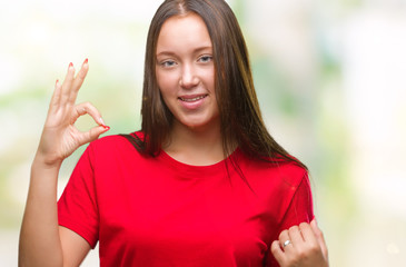 Young beautiful caucasian woman over isolated background smiling positive doing ok sign with hand and fingers. Successful expression.