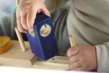 Criança brincando de encaixar brinquedo didático de madeira