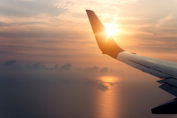 flying and traveling, view from airplane window on the wing on sunset time.Morning sunrise with Wing of an airplane. Photo applied to tourism operators. picture for add text message or frame website.