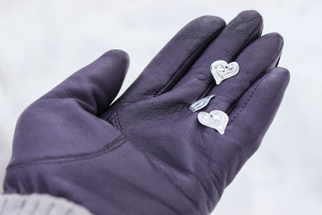 Hands of girl in winter gloves hold hearts