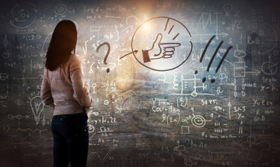 Young woman looking on the black board with mathematical formulas and calculations. Bright idea, way of thinking, discovery and challenge concept.
