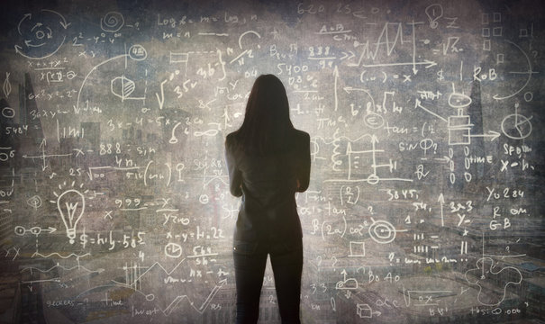 Young woman looking on the black board with mathematical formulas and calculations. Bright idea, way of thinking, discovery and challenge concept.