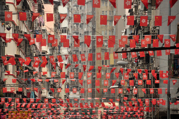 View of rows of strings with waving red flags on street of Singapore. Plenty of red flags on city street.
