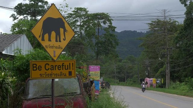 A warning sign for crossing elephants on a road in Thailand Cropped