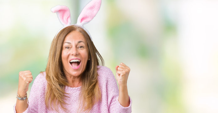 Middle age brunette woman wearing easter rabbit ears over isolated background celebrating surprised and amazed for success with arms raised and open eyes. Winner concept.