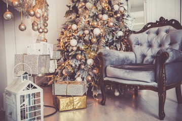 the armchair and the fireplace, gifts under the Christmas tree, a cozy new year 2019.