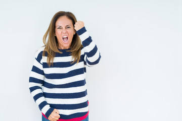 Beautiful middle age woman wearing navy sweater over isolated background angry and mad raising fist frustrated and furious while shouting with anger. Rage and aggressive concept.