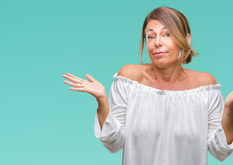 Middle age senior hispanic woman over isolated background clueless and confused expression with...