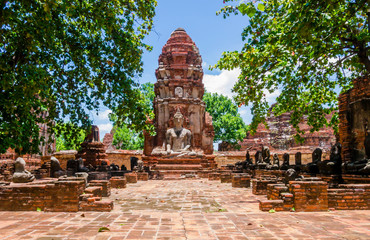 Thailand, Stupa and Buddha sculpture surrounded by trees in Ayutthaya old Temple
