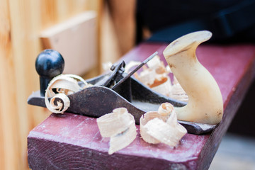 Joinery – old wooden plane and chips in a workshop of the carpenter