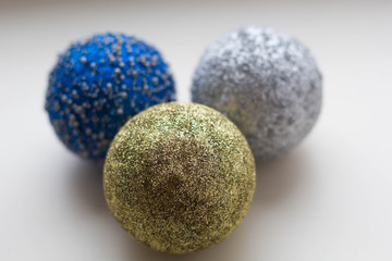 three multicolored christmas balls on a white background close-up