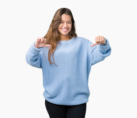 Young beautiful brunette woman wearing blue winter sweater over isolated background looking confident with smile on face, pointing oneself with fingers proud and happy.