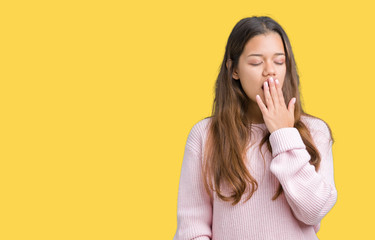 Young beautiful brunette woman wearing pink winter sweater over isolated background bored yawning tired covering mouth with hand. Restless and sleepiness.