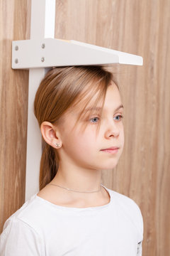 Child check up - measuring stature of preteen girl with stadiometer