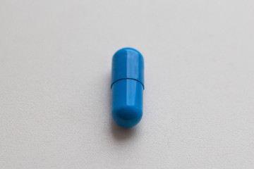 Blue medical pill on white background close up