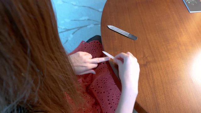 Woman performing a manicure on her fingernails