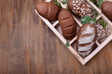 Assortment of little loaves of rye bread in a wooden box. Copy space