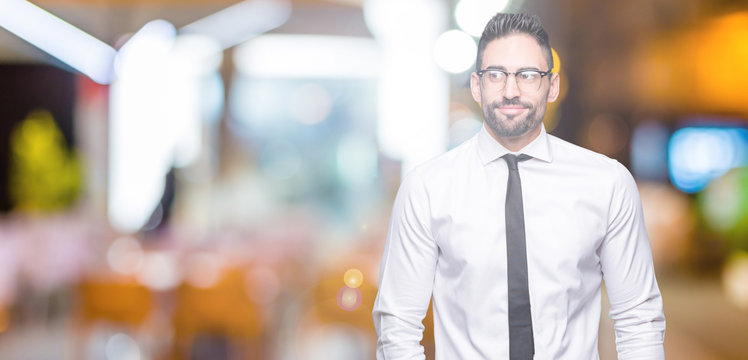 Young handsome business man wearing glasses over isolated background smiling looking side and staring away thinking.
