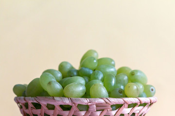 green grape in a bowl on colored background