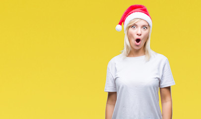 Young beautiful blonde woman wearing christmas hat over isolated background afraid and shocked with surprise expression, fear and excited face.